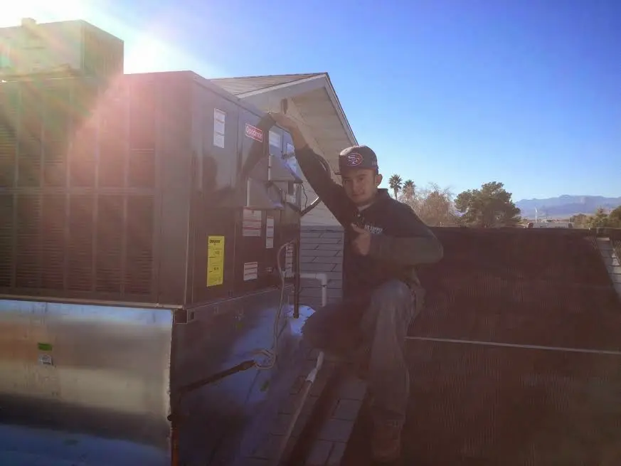 HVAC technician performing Air Duct Repair on a rooftop unit in Clay